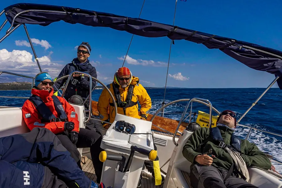 Vier Crewmitglieder entspannt an Deck
